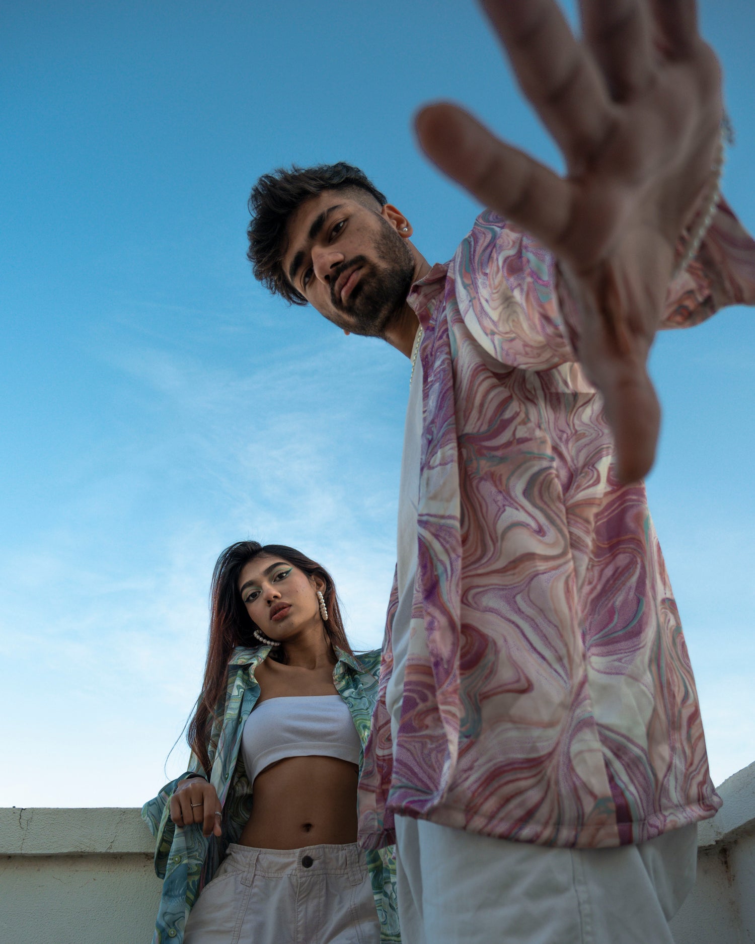A couples posing in floral printed shirts